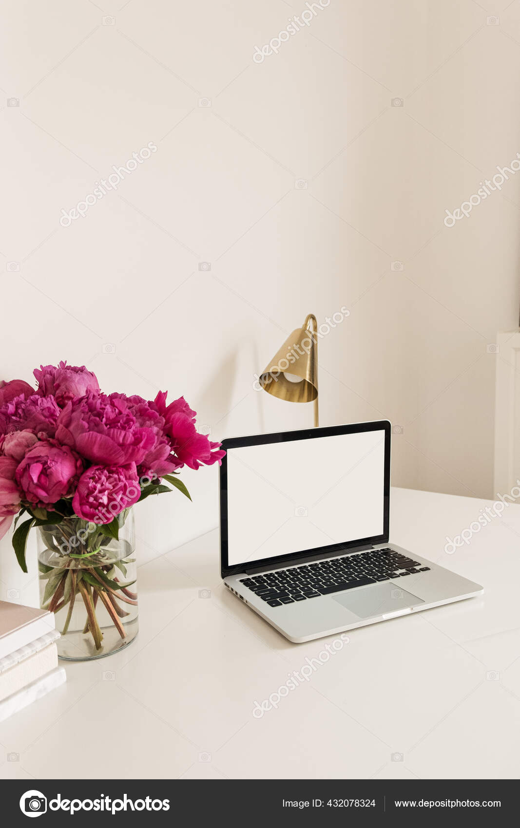 オフィスの机のテーブルワークスペースには 空白のコピースペースがノートパソコンの画面をモック ピンクの牡丹の花の花束とモダンなスタイリッシュなインテリアデザイン フロントビューブログ ソーシャルメディア ウェブサイトのヒーローテンプレート ストック写真