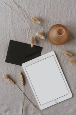Boş ekran tableti, zarf, dekorasyon, kulak / buğday kulak sapları, gri yıkanmış keten bezler. Düzlük, üst görünüm minimalist yaşam tarzı blogu, web sitesi şablonu. Boşluk modellemesini kopyala.