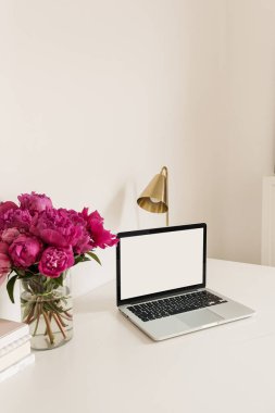 Boş fotokopi alanı olan ofis masası çalışma alanı dizüstü bilgisayar ekranı gibi. Pembe şakayık çiçekli modern ev dekorasyonu. Önizleme günlüğü, sosyal medya, web sitesi kahramanı şablonu.