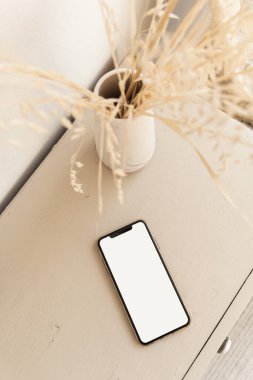 Bej renkli pastel masada düz ekran akıllı telefon. Düz yerde, üst tarafta. Boşluk düzenleme şablonunu kopyala.