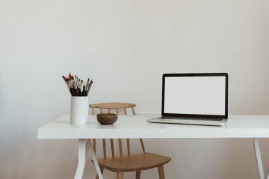 Masada boş ekran olan dizüstü bilgisayar. Estetik asgari ofis çalışma alanı iç tasarım şablonu kopya alanı.