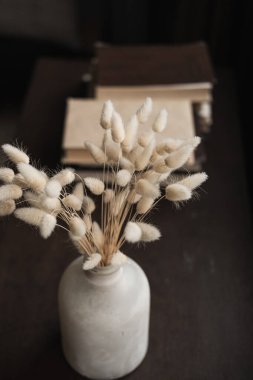 Closeup of bunny rabbit tail grass bouquet in vase on the table. Aesthetic minimal home interior design concept. clipart