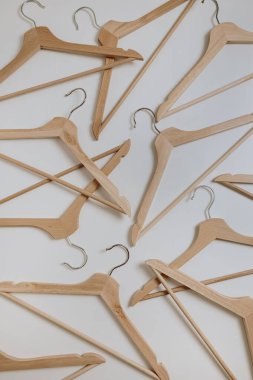 Beyaz arka planda giysi desenleri için ahşap askılar. Düz yatak, üst görünüm minimalist moda, ticaret, alışveriş, mağaza, satış konsepti.