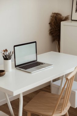 Masada boş ekran olan dizüstü bilgisayar. Estetik asgari ofis çalışma alanı iç tasarım şablonu kopya alanı.