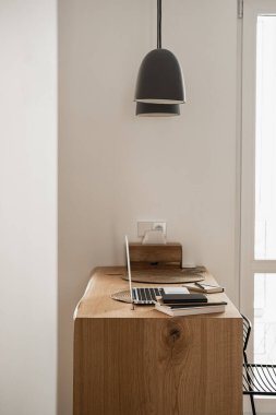 Dizüstü bilgisayar ve defterler ahşap masada. Serbest İşyeri Çalışma Alanı.