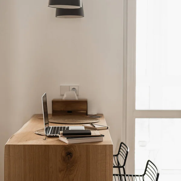 モダンなインテリアデザイン 頑丈な木製のスタンド 吊りランプ ラップトップコンピュータ 白い壁で飾られたスタイリッシュな明るいリビングルーム 審美的なミニマリストリビングルーム — ストック写真