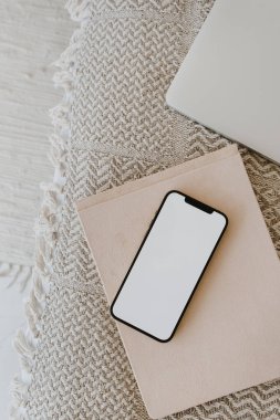 Hasır bankta dizüstü bilgisayarı olan boş ekran cep telefonu düzlüğü. Estetik düz alan, üst görünüm günlüğü, sosyal medya, şablon.
