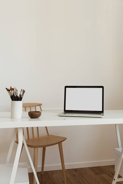 Laptop computer with blank screen on table. Aesthetic minimal office workspace interior design template with mockup copy space.