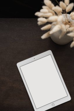 Boş ekran tableti düzlüğü, kahverengi arka planda tüylü tavşan tavşan masalı. Ofis masası çalışma alanı. Estetik kadın, kız patron işi, kopya alanı ile çalışma şablonu. Düz yatış, üst görünüm.