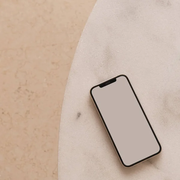 Blank screen smart phone on marble table. Flat lay, top view. Copy space mockup template.