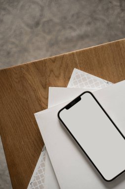 Ahşap masada boş ekran cep telefonu. Düz yatak, üst görünüm minimalist blog, web sitesi şablonu. Boşluk modellemesini kopyala.