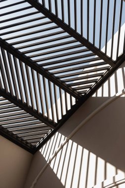 Bej duvarları ve duvarlarında güneş ışığı gölgeleri olan modern doğu tarzı bir bina. Estetik asgari mimari ön cephe tasarım kavramı arka planı