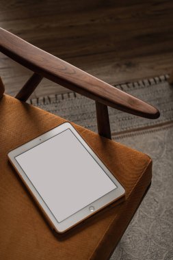 Eski sandalye ve halının üzerinde boş ekran tableti. Ofis masası çalışma alanı. Bayan, kız patron estetik işi, kopya alanı ile çalışma şablonu