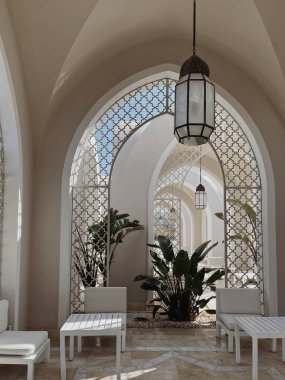 Bej duvarları, pencereleri, lambası ve güneş ışığı gölgeleri olan modern doğu tarzı bir bina. Soyut mimari ön plan tasarım konsepti. Tropik yaz tatili kompozisyonu