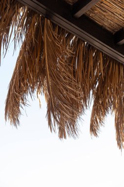 Mavi gökyüzü manzaralı plajda dinlenmek için dinlenme yeri. Kuru palmiye yapraklarından yapılmış çadır. Tropikal Cennet Oteli 'nde lüks yaz tatili