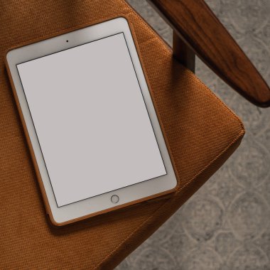 Vintage sandalyede boş ekran tableti. Düz yatak, üst görünüm minimalist blog, web sitesi, uygulama şablonu. Boşluk pedi modelini kopyala.