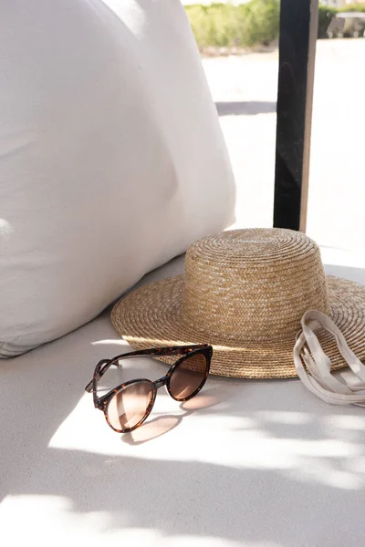 女性のファッションアクセサリー スタイリッシュな女性のサングラス わらの帽子 枕付きの白いラウンジソファの買い物袋 ファッションブログ ウェブ ソーシャルメディア — ストック写真