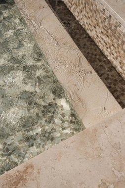 Yüzme havuzu manzarası, berrak mavi su ve güneş ışığı yansımaları. Minimum estetik yaz tatili konsepti