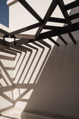 Bej duvarları ve demiryolu güneş ışığı gölgeleri olan modern doğu tarzı bir bina. Soyut mimari ön cephe tasarım kavramı