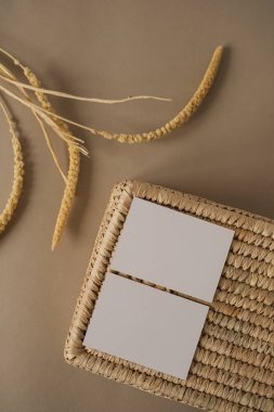 Fotokopi alanı olan boş kâğıt kağıtlar. Tarafsız bej arka planda rattan tabut. Asgari estetik markalaşma, blog, sosyal medya şablonu. Düz yatış, üst görünüm