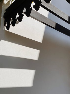 Bej duvarları ve demiryolu güneş ışığı gölgeleri olan modern doğu tarzı bir bina. Soyut mimari ön cephe tasarım kavramı