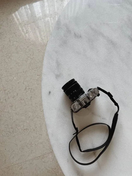 Retro photo camera on marble table. Flat lay, top view
