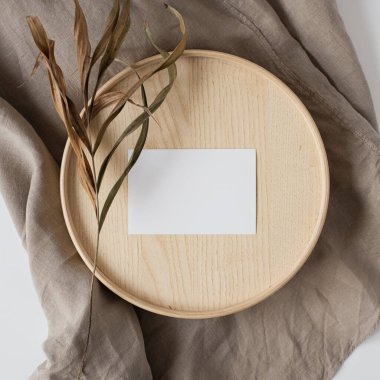 Sahte kopya alanı, tahta tabut ve gri keten battaniye üzerinde kuru çiçekler olan boş kağıt kağıtlar. Asgari estetik iş markası, blog, sosyal medya şablonu. Düz yatış, üst görünüm