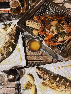 Kızarmış deniz ürünleri tabağı: deniz levreği, yengeç, istiridye, karides, soslu kalamar. Köpüklü gül şarabıyla birlikte şarap kadehi. Romantik akşam yemeği. Düz yatış, üst görünüm