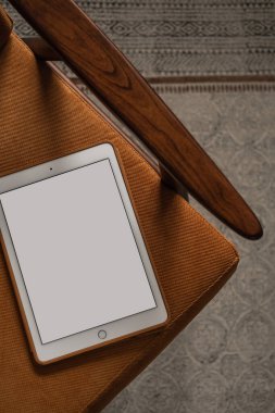 Vintage sandalyede boş ekran tableti. Düz yatak, üst görünüm minimalist blog, web sitesi, uygulama şablonu. Boşluk pedi modelini kopyala.