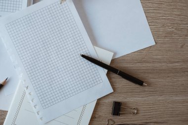 Ofis masası çalışma alanı, boş kağıt kağıtlar, defter, ahşap arka planda otlar. Düz konum, üst görünüm blogu, web, sosyal medya kavramı.