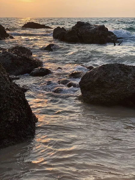 日落或日出时带着岩石和波浪的海滨景色 — 图库照片