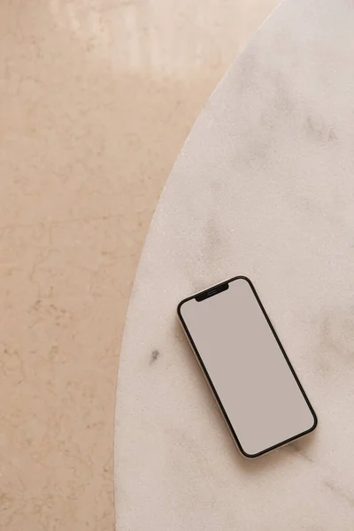 Blank screen smart phone on marble table. Flat lay, top view. Copy space mockup template.