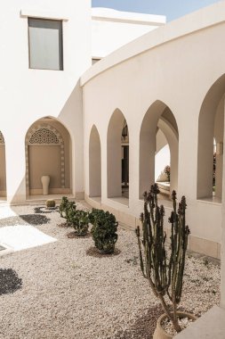 Bej duvarları, pencereleri ve güneş ışığı gölgeleri olan modern doğu tarzı bir bina. Estetik asgari mimari ön cephe tasarım kavramı arka planı