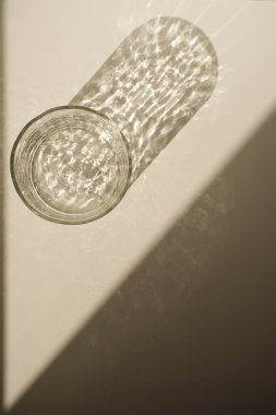 Minimum lüks estetik konsept. Beyaz arka planda parlak güneş ışığı gölgesi olan bohem kristal cam.