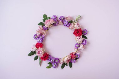 Pembe arka planda gül tomurcuklarından yapılmış yuvarlak çerçeve. Flatlay, üst manzara. Yukarıdan bak. Boşluk modellemesini kopyala.