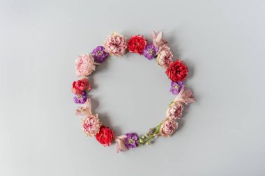 Yuvarlak çerçeve çelengi. Mavi arka planda pembe gül çiçeklerinden yapılmış boş bir kopya alanı var. Düz konum, üst görünüm minimal çiçek bileşimi.