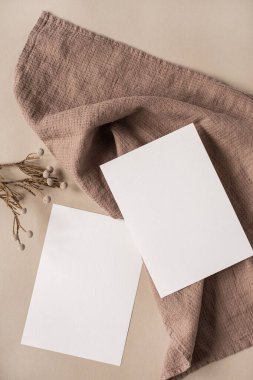 Estetik Parisli stil markalaştırma şablonu. Sahte kopya alanı olan boş kağıt kağıtlar, kuru çiçek dalları ve tarafsız bej arka planda kumaş. Düz yatış, üst görünüm