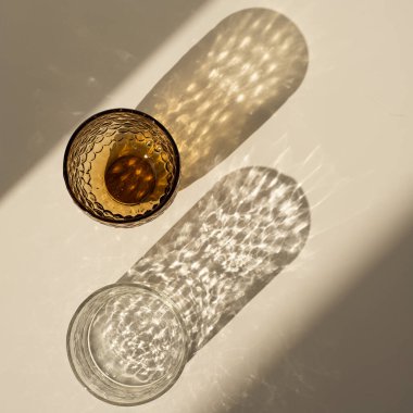 Tarafsız bej arka planında parlak güneş ışığı gölgesi olan estetik bohem kristal cam. Düz yatış, üst görünüm