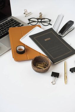 Estetik ofis masası çalışma alanı dizüstü bilgisayarı, defteri, beyaz arka planı olan masa örtüsü. Günlük, web sitesi, sosyal medya kavramı.