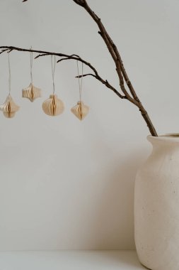 Seramik vazo dallı minimalist dekoru ve asılı kağıt süslemeleri. Doğal Estetik, Tarafsız Tonlar, Basit Tasarım, İskandinav Tarzı, İç Dekorasyon