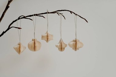 Doğal Basitlik. Dallardaki kağıt süsler. Minimalist Dekor ve Tarafsız Renklerde Zarif Zarafet