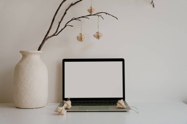 Ev ofisini dizüstü bilgisayar, kırsal vazo ve kağıt fenerlerle donatmak. Yumuşak nötr tonlar. Sakin yaratıcı alan