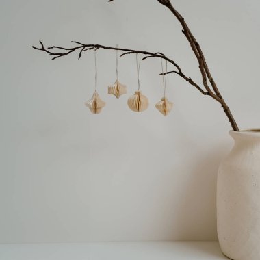 Seramik vazo dallı minimalist dekoru ve asılı kağıt süslemeleri. Doğal Estetik, Tarafsız Tonlar, Basit Tasarım, İskandinav Tarzı, İç Dekorasyon