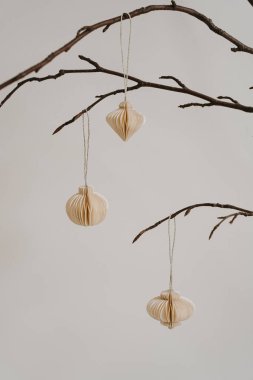 Çıplak dallarda minimalist kağıt süslemeleri. İskandinav Tarzı Doğal Zarafet, Tarafsız Tonlar, Sanatsal Basitlik