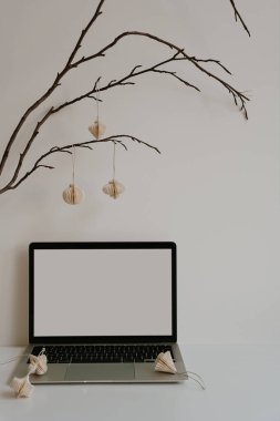 Pürüzsüz dizüstü bilgisayarı ve yumuşak kağıt fenerleri olan çağdaş çalışma alanı. Tarafsız renkler ve basit tasarım ofis ortamı