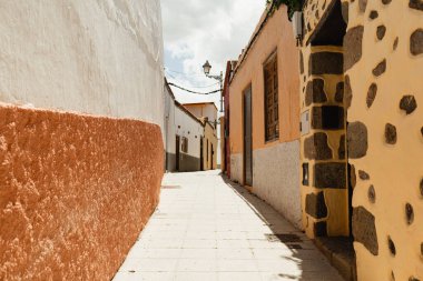Büyüleyici sarı binaların yer aldığı manzaralı şehir şeridi göz kamaştırıcı mavi bir arkaplan üzerine kurulmuş.