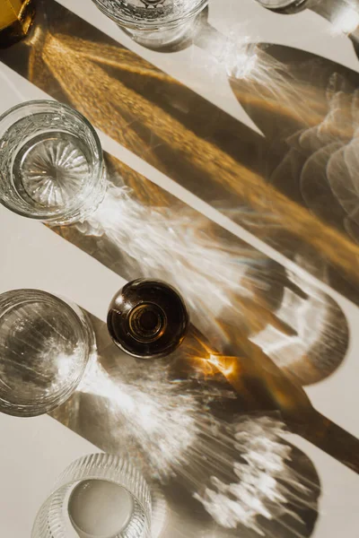 Güneş Işığı Kristal Gözlükleri ve Kehribar Şişe, Minimalist Ayarlarda Altın Yansımalar