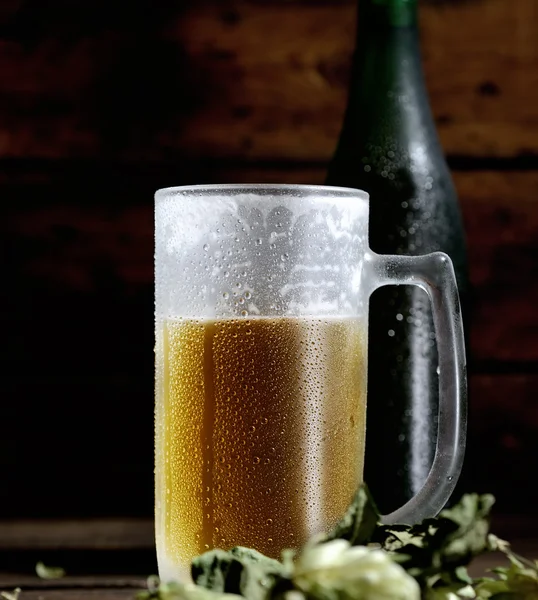 Beer glass with bottle and hops