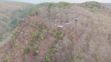 Uzak bir köyü çevreleyen Kuru bir arazinin çarpıcı bir hava görüntüsü Bir yamaçtaki yükseltilmiş bir köy