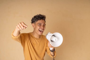 Neşeli bir genç adam bir mesaj iletmek için megafon kullanıyor..